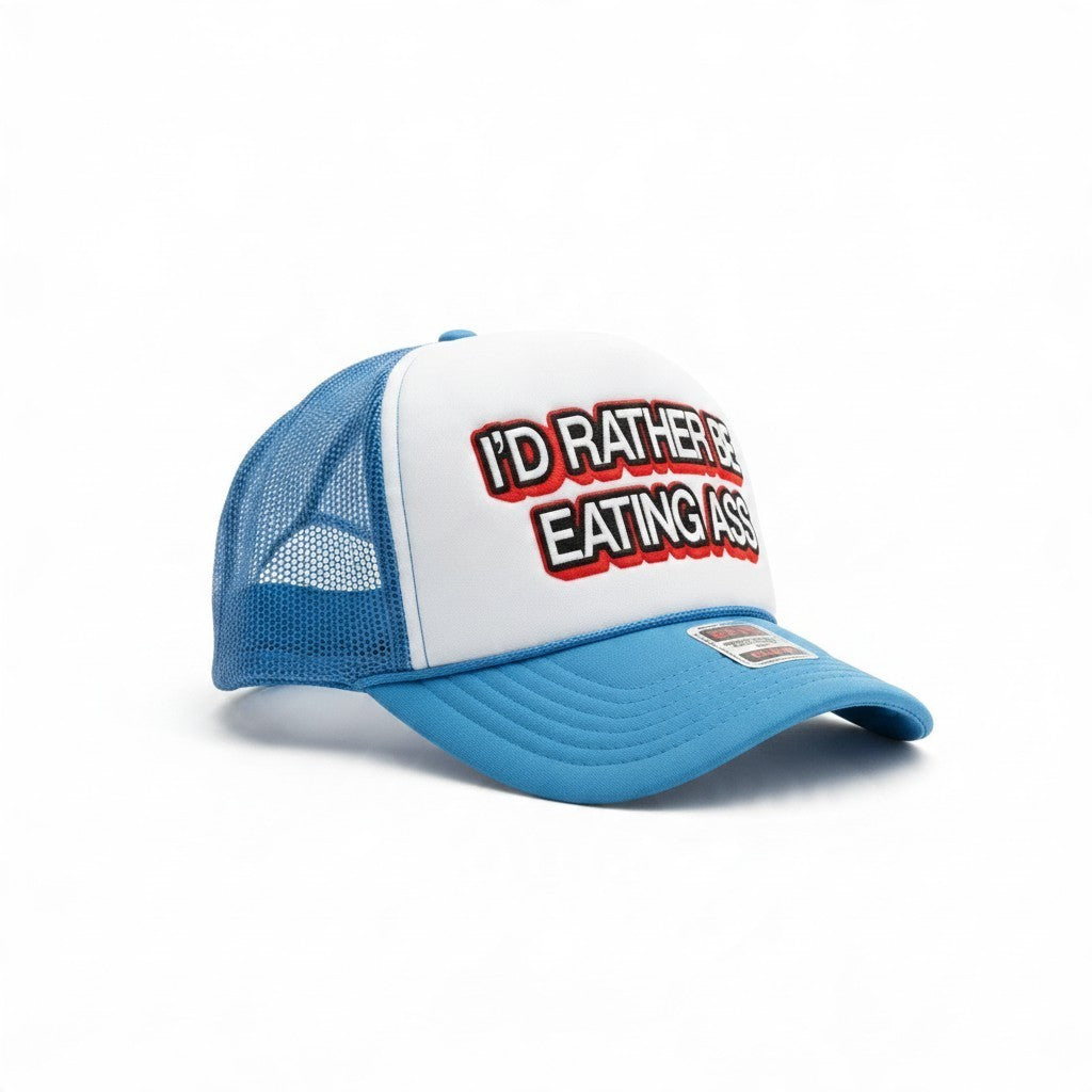 Dirty Merch Apparel blue and white trucker hat with I'd Rather Be Eating Ass graphic text on the foam front panel.