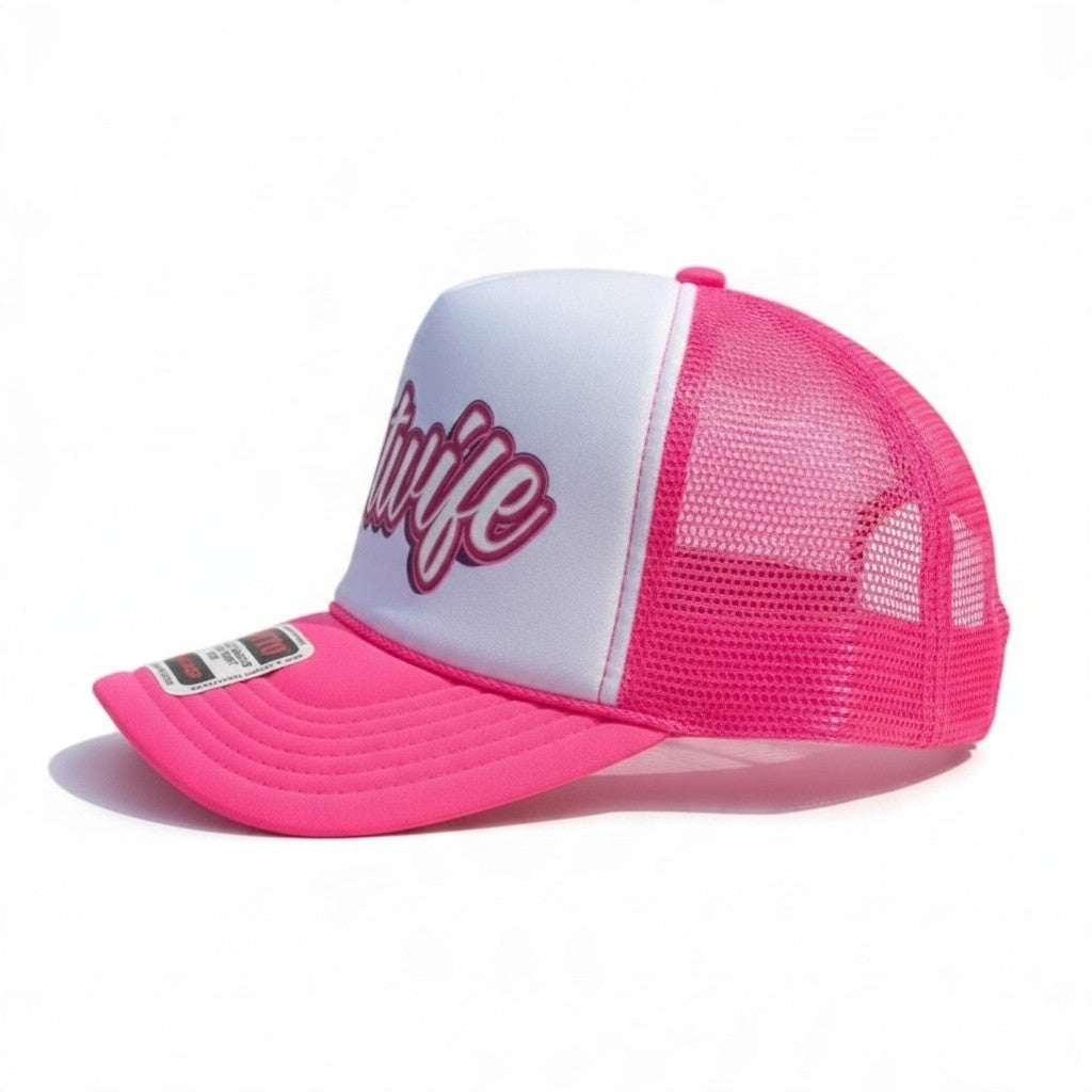 Dirty Merch Apparel hotwife trucker hat with white foam front, pink mesh back, and embroidered pink text design.