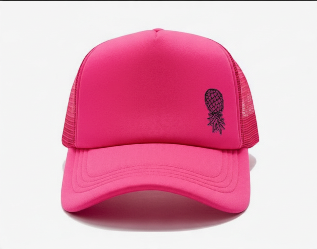 Dirty Merch Apparel neon pink trucker hat with an embroidered black pineapple design on the front foam panel