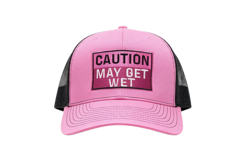Dirty Merch Apparel pink and black trucker hat with embroidered Caution May Get Wet text on a foam front panel