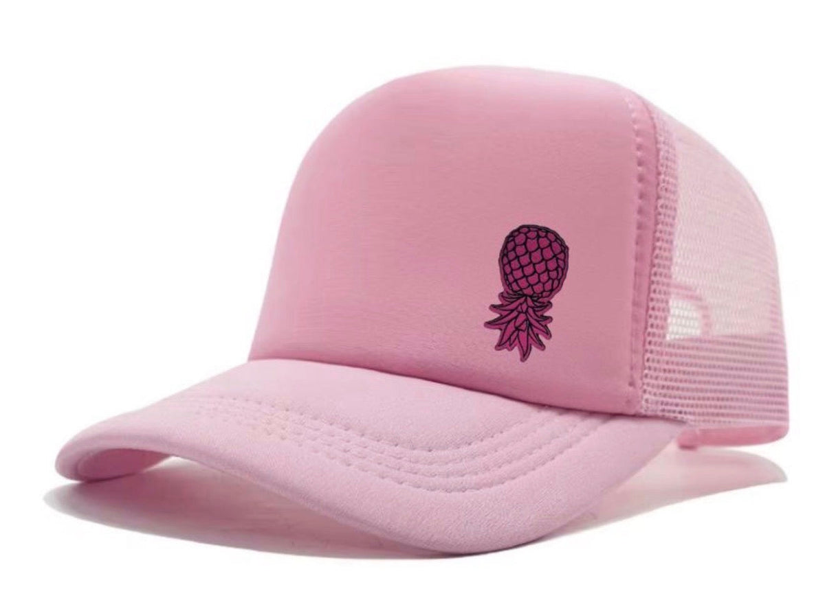 Dirty Merch Apparel pink trucker hat with a black embroidered pineapple design and breathable mesh back panels.