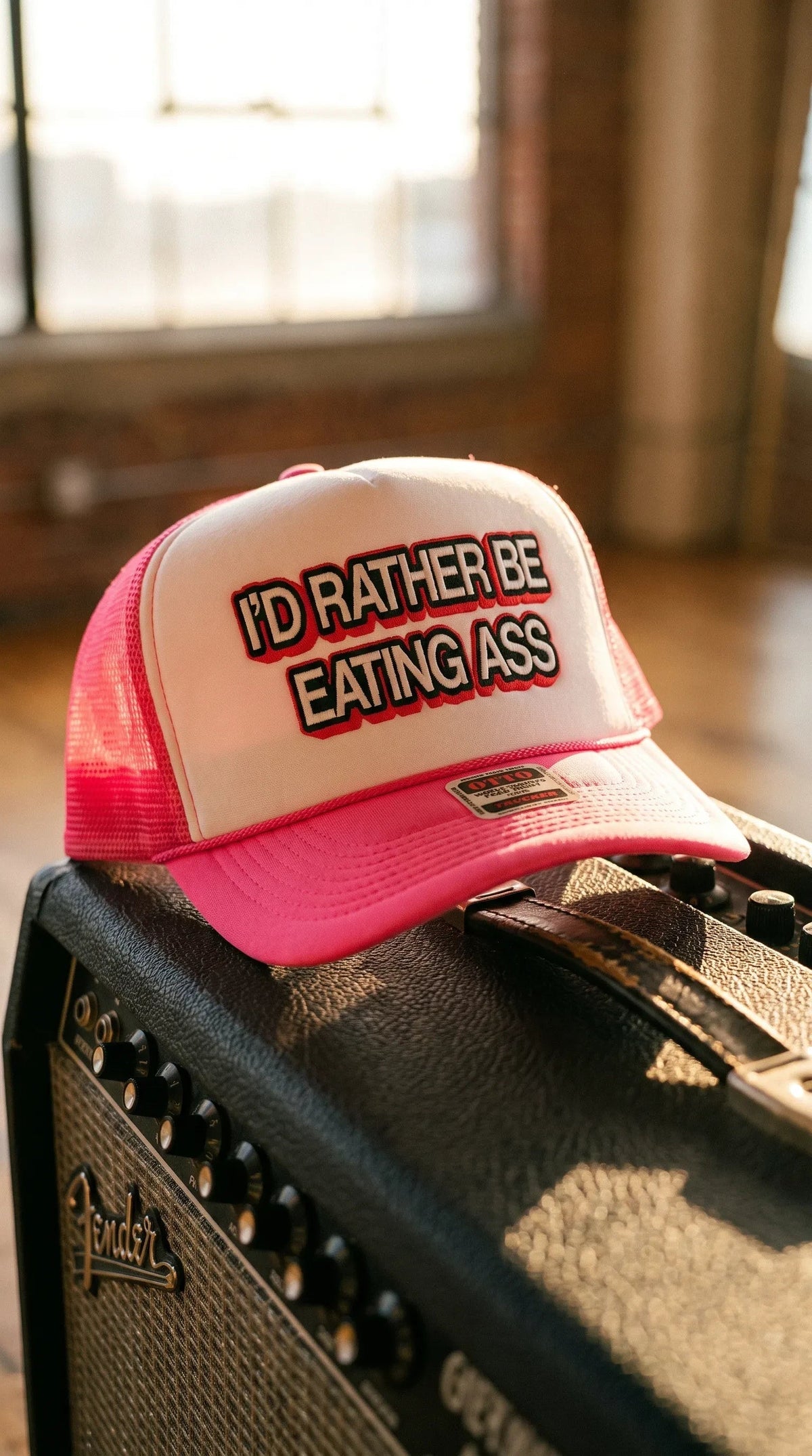 Dirty Merch Apparel Richardson 112 trucker hat in pink and white with embroidered text on a guitar amplifier